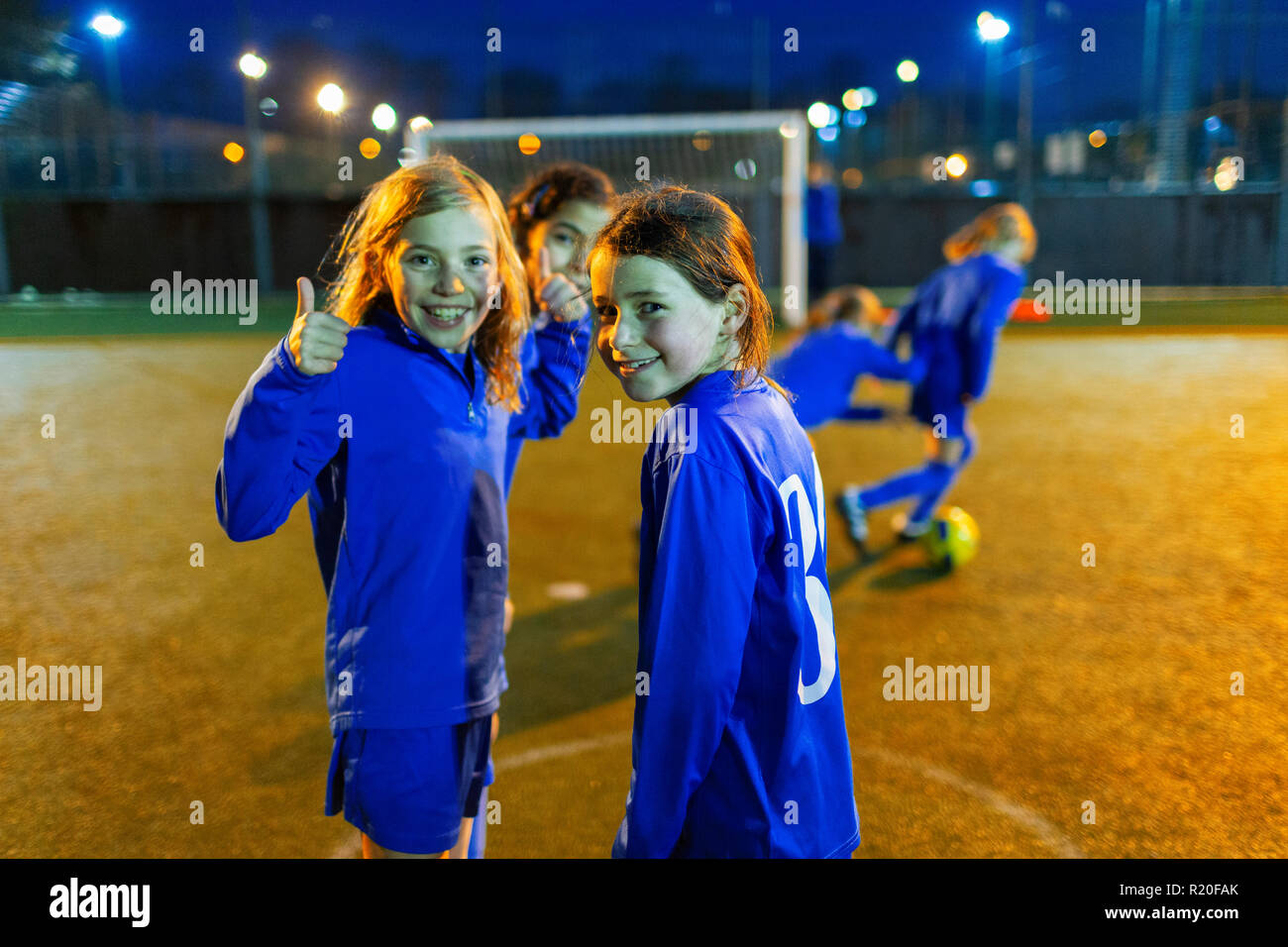 Portrait confiant girl playing soccer, gesturing thumbs-up Banque D'Images