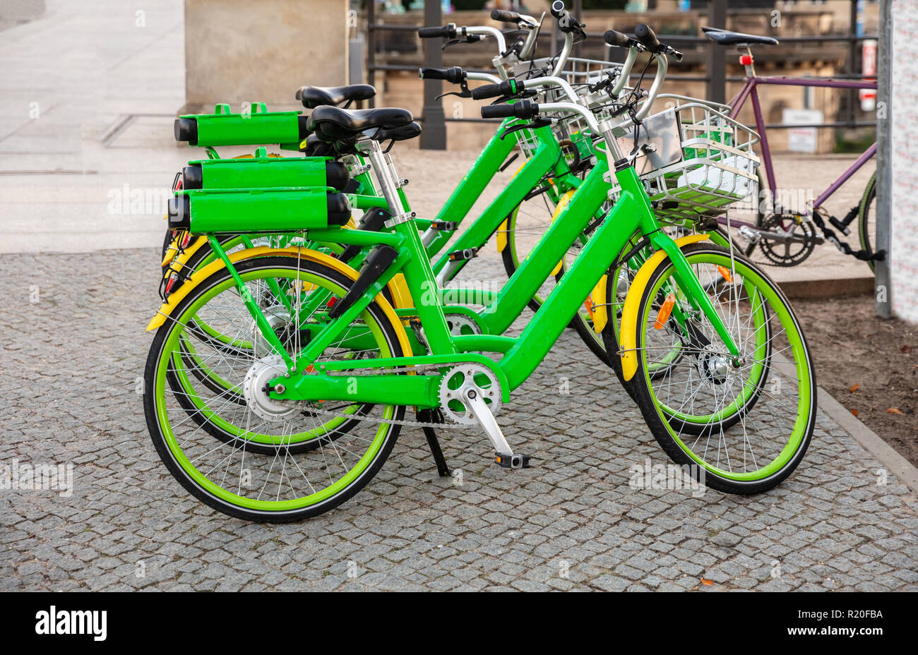 Des vélos de location verte avec des paniers en stationnement sur une rue pavée, à Berlin, Allemagne, papier peint. Banque D'Images