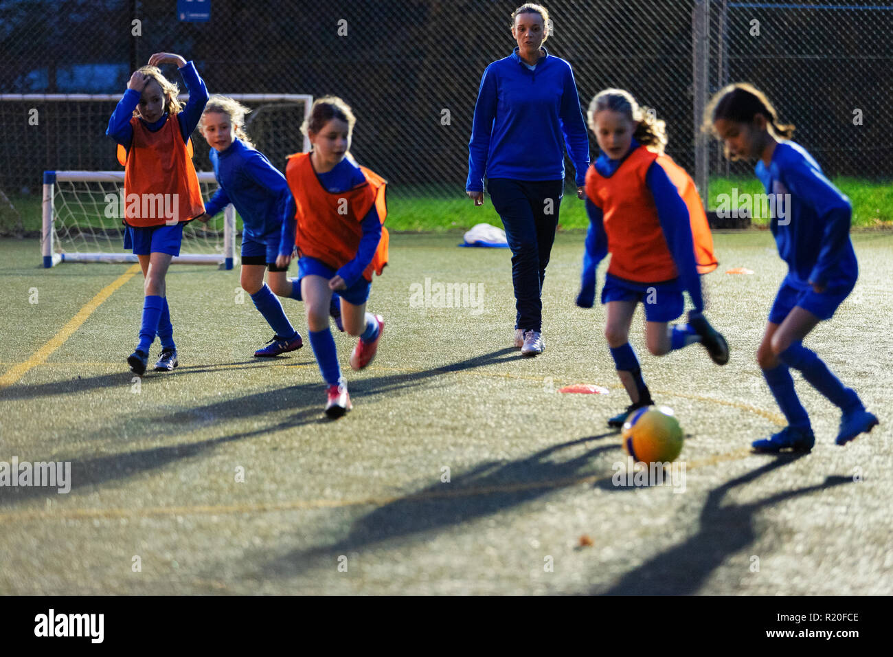 Entraîneur de football regarder des filles sur le terrain pratique Banque D'Images
