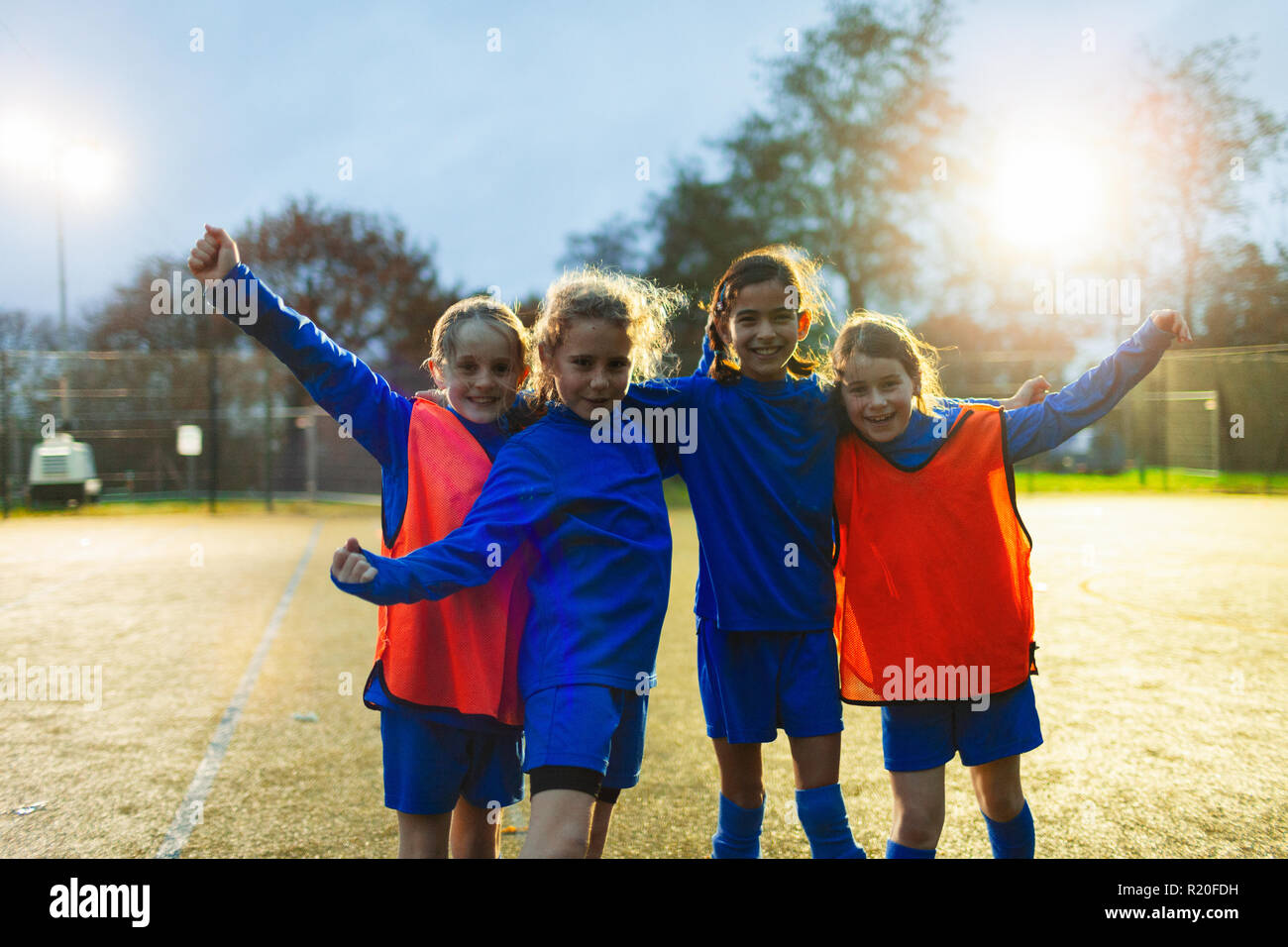 Équipe féminine de soccer Portrait confiant cheering on field Banque D'Images