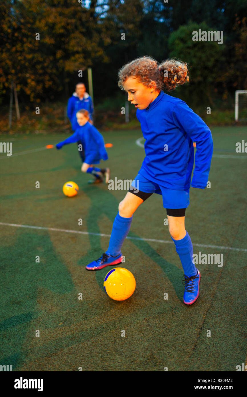 Girl soccer player pratiquer sur terrain Banque D'Images