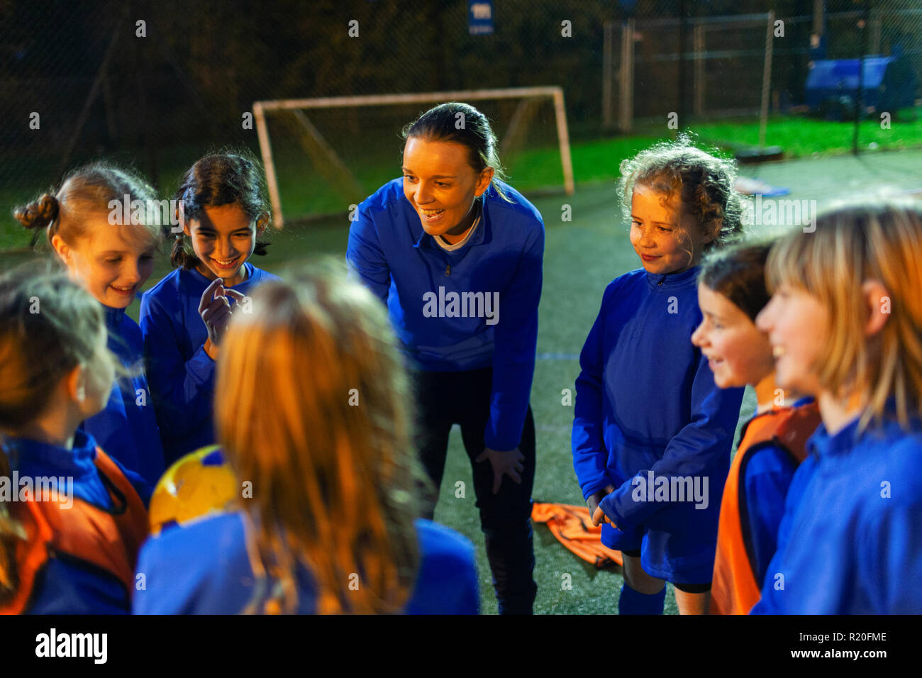 L'équipe féminine de soccer coach à l'écoute de la nuit sur le terrain Banque D'Images