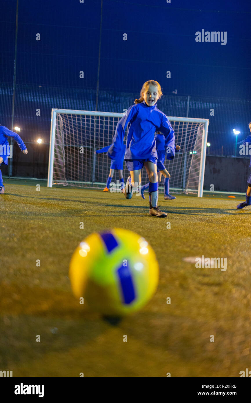 Girl soccer player pratiquer sur terrain de nuit Banque D'Images