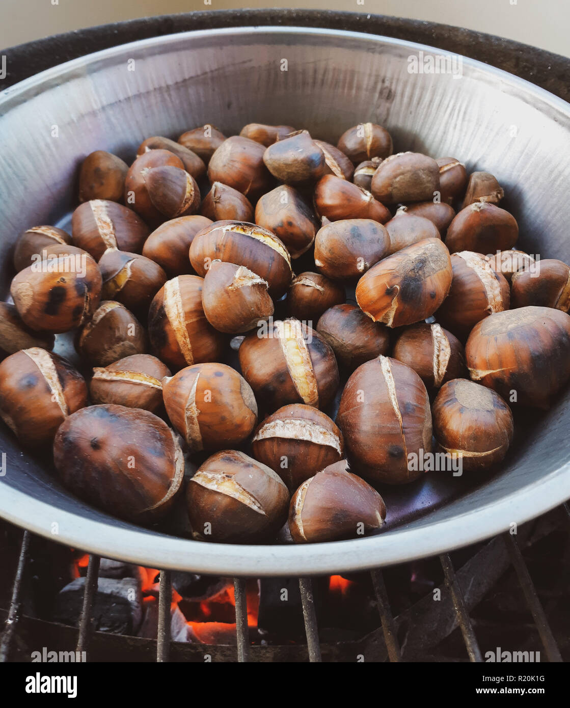 Châtaignes grillées dans une poêle de fer cuits sur le grill. Banque D'Images