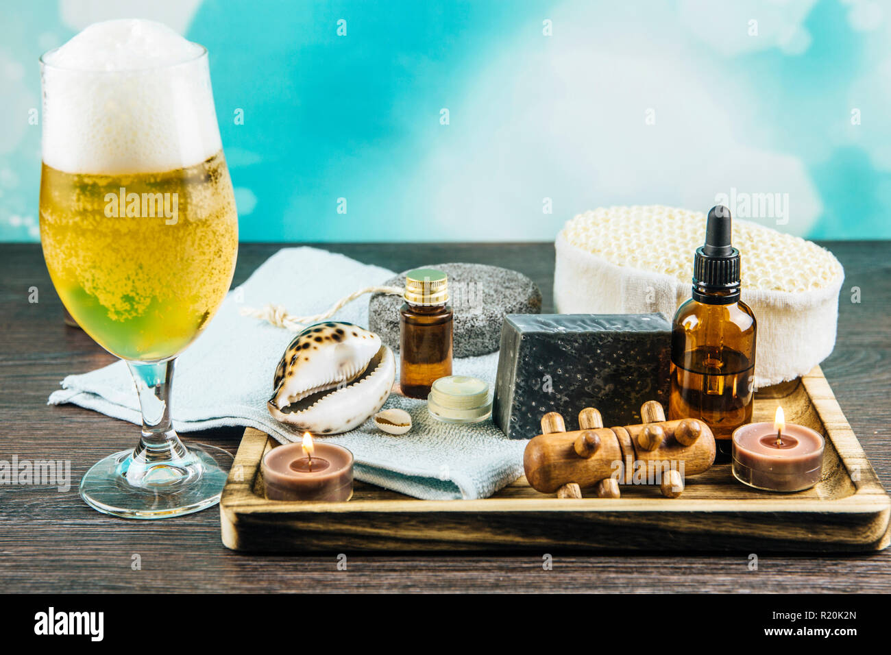 Composition plateau en bois avec différents groupe de spa essentials, beard, huile, savon argile grise éponges naturelles, bougies, huile arôme verre de bière sur Banque D'Images