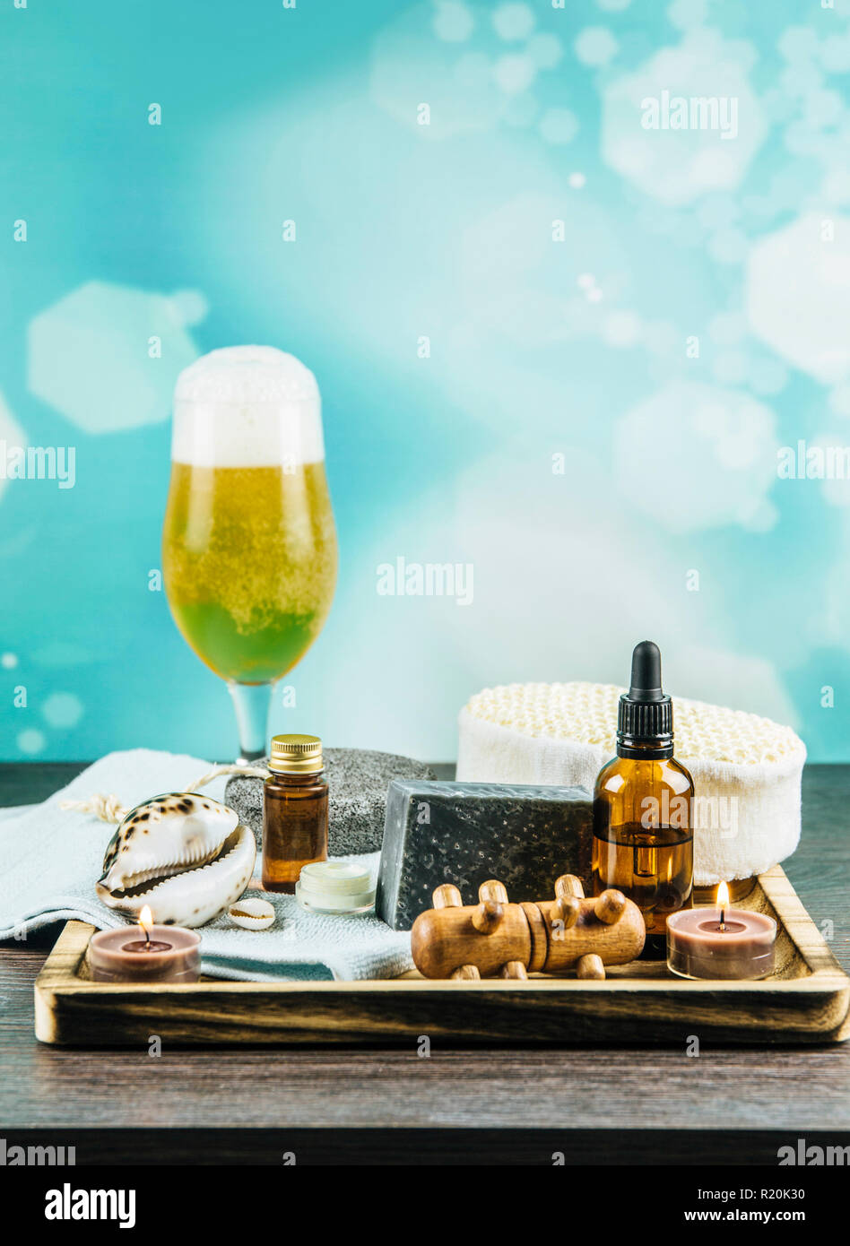 Composition plateau en bois avec différents groupe de spa essentials, beard, huile, savon argile grise éponges naturelles, bougies, huile arôme verre de bière sur Banque D'Images