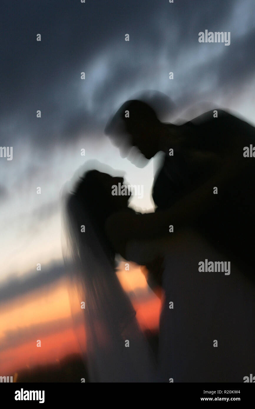 La silhouette d'une femme et un homme après leur mariage prêt à baiser pendant un coucher de soleil à Phoenix, Arizona. Banque D'Images