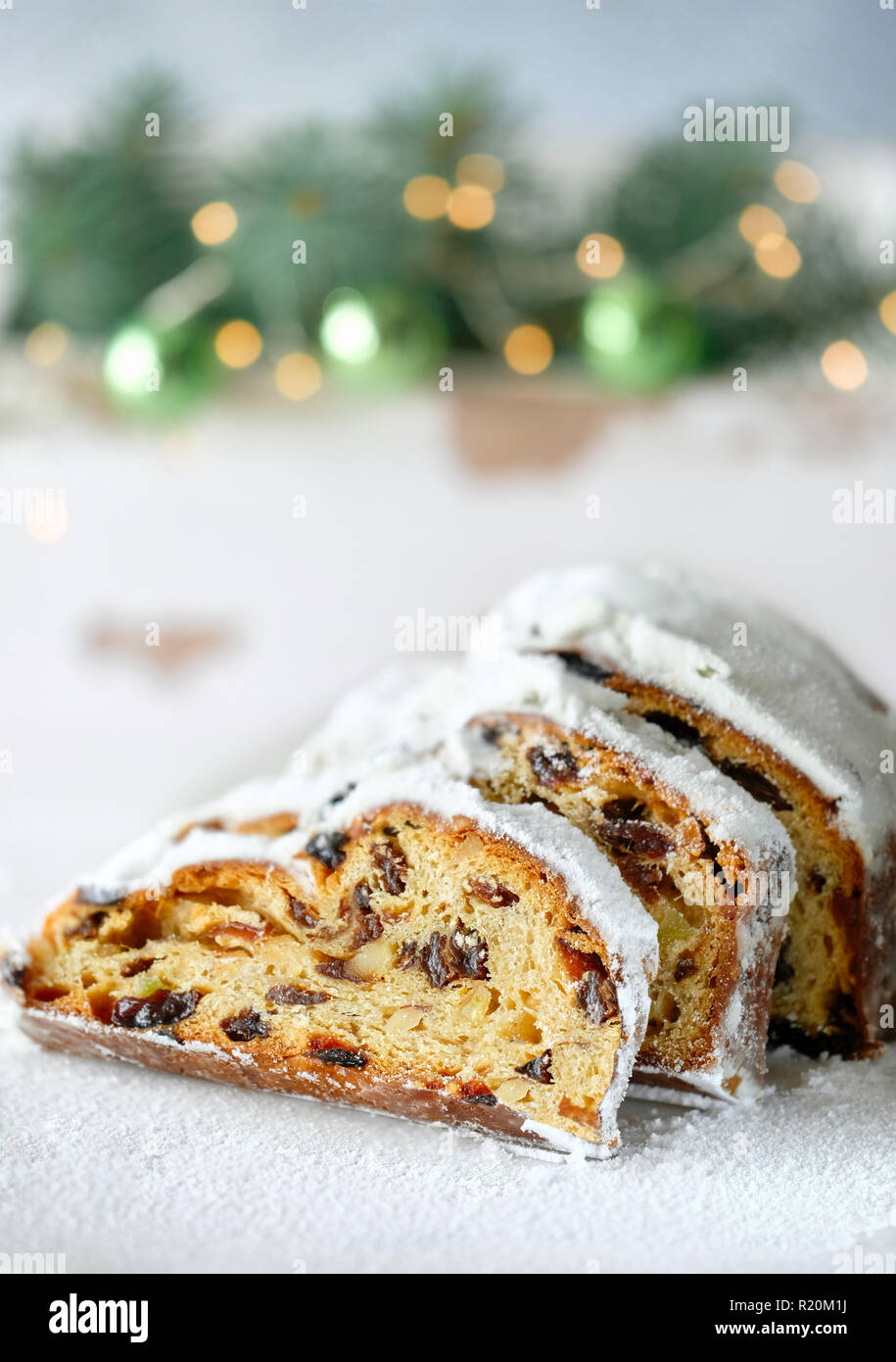 Stollen de Noël blanc sur fond de fête avec des brindilles de sapin et de bibelots. Dessert traditionnel Allemand pour célébration de Noël. Banque D'Images