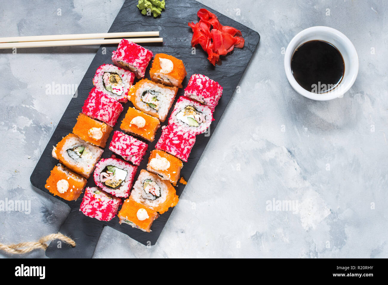 Un assortiment de rouleaux de sushi set servi sur plaque sur fond de béton. Vue d'en haut Banque D'Images