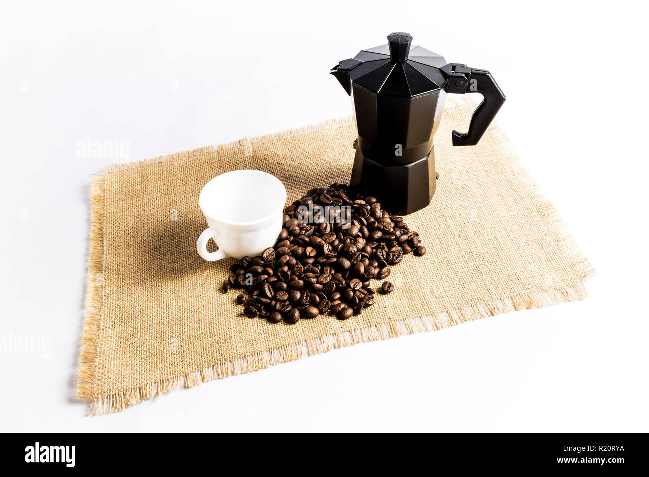 Les grains de café à côté d'une cafetière italienne et une tasse sur une  nappe en tissu Photo Stock - Alamy