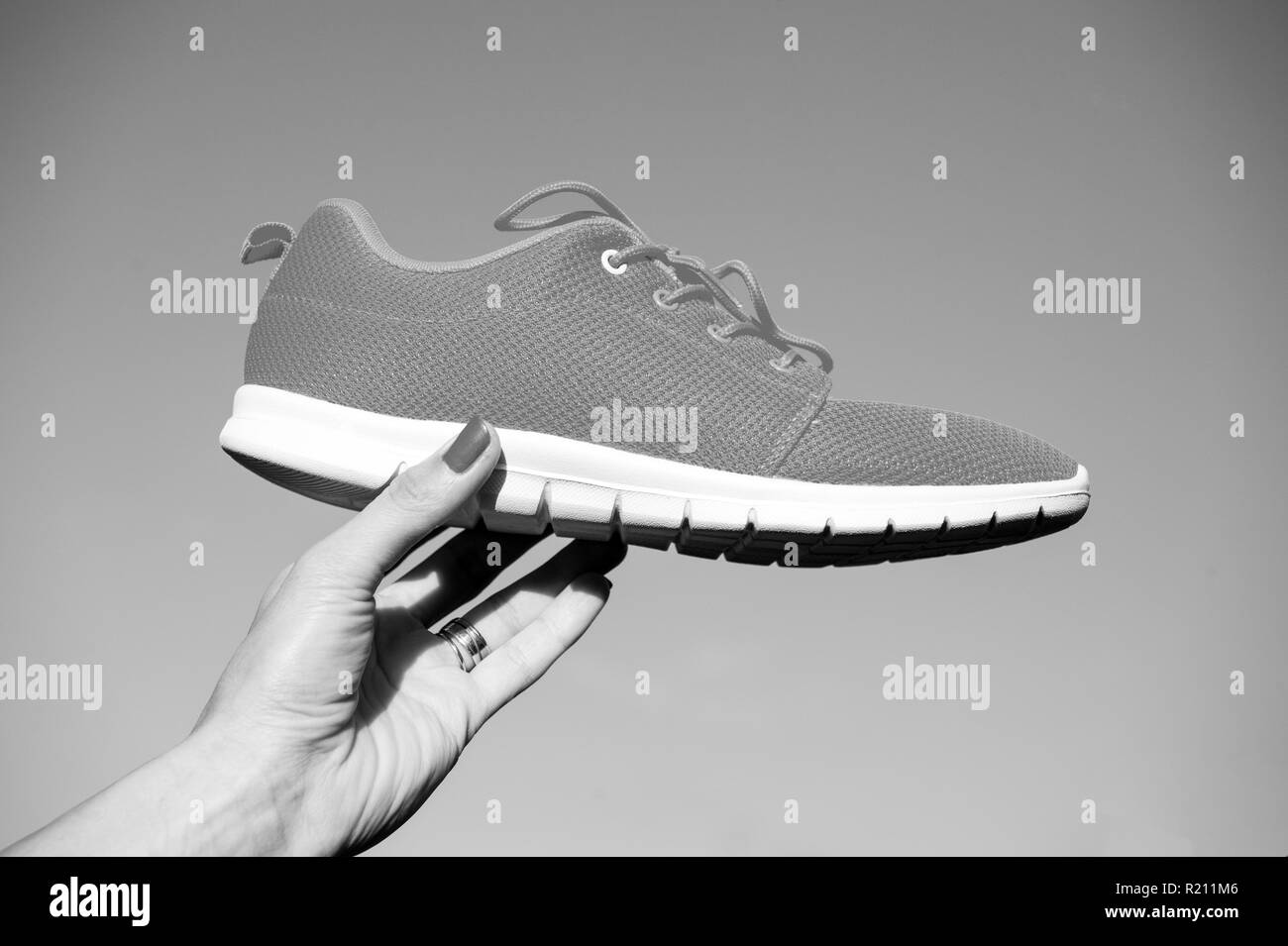 Chaussures sport sport sur fond de ciel bleu. Sports à l'air libre. woman holding orange chaussures de conditionnement physique et de la santé Banque D'Images