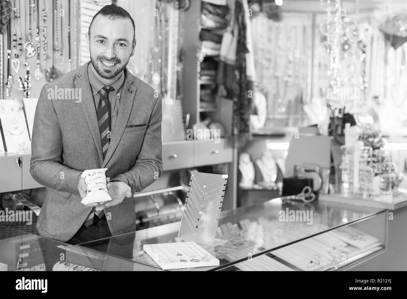 Smiling vendeur montrant différents bracelets dans la bijouterie Banque D'Images