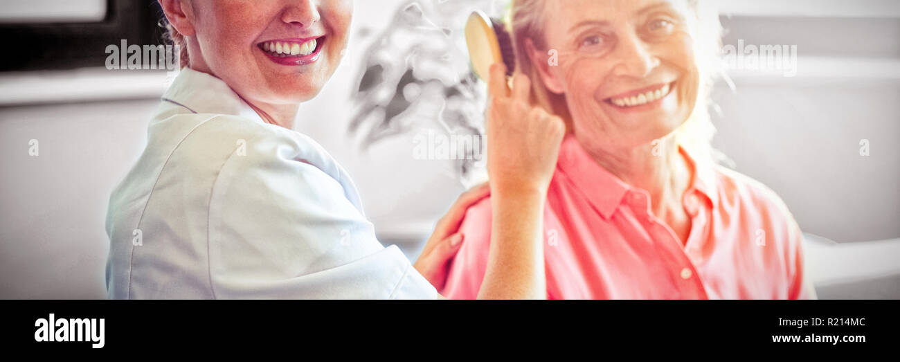 Infirmière peigner les cheveux de senior woman Banque D'Images