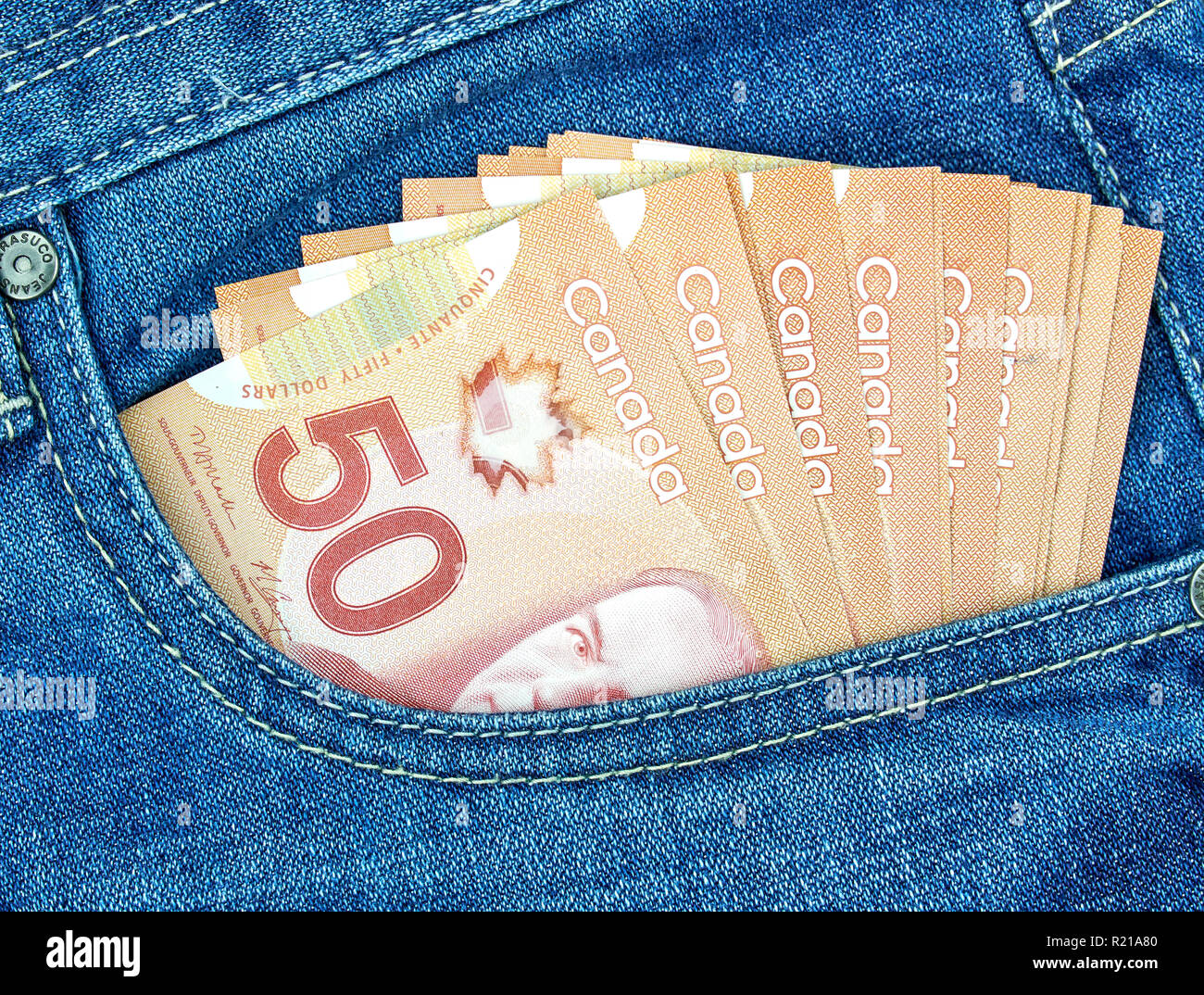 L'argent canadien dans une poche d'un jeans bleu Banque D'Images
