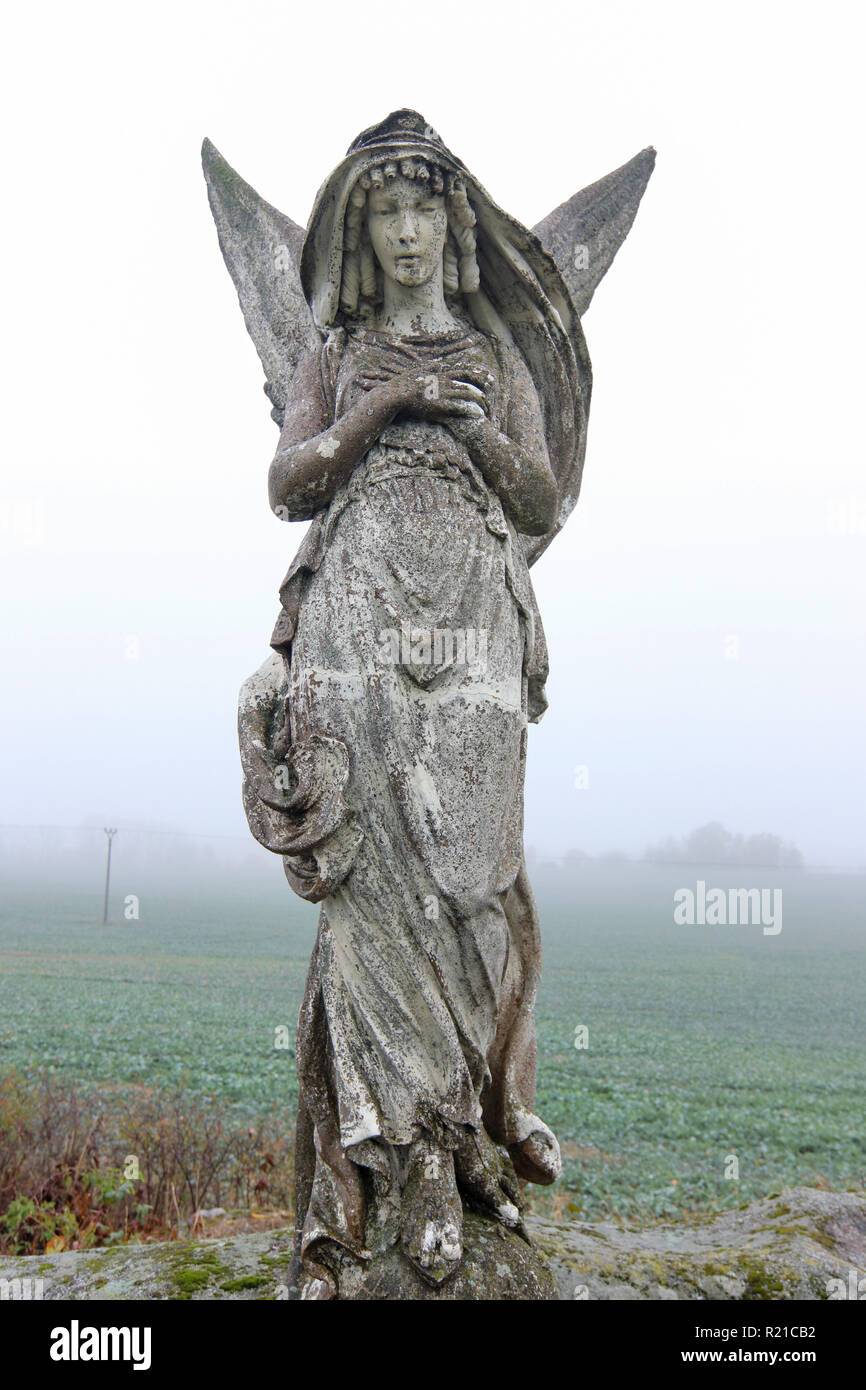 Lone statue d'un ange dans les champs Banque D'Images