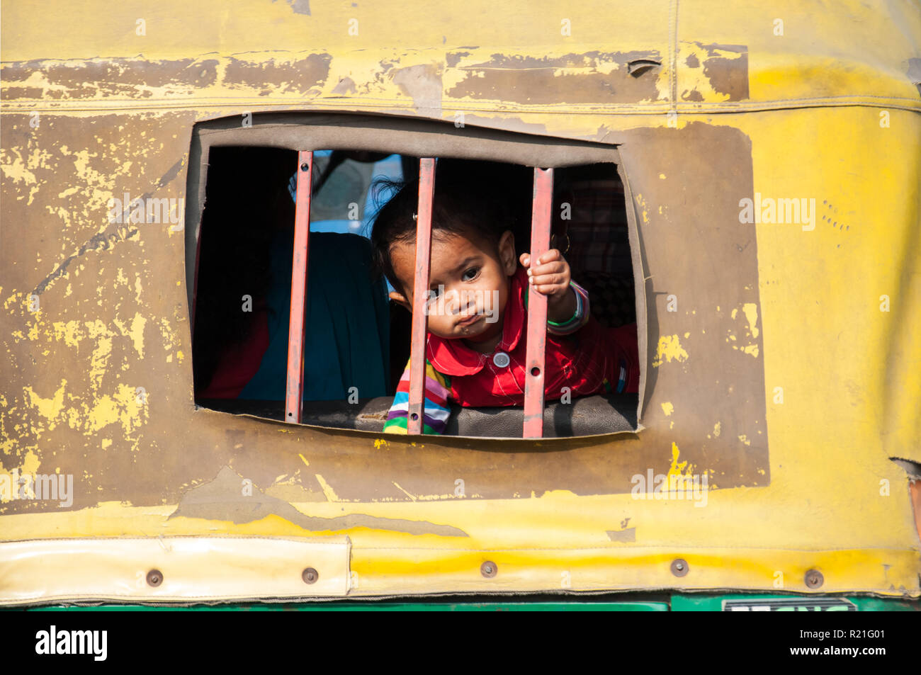 Inde dans la vie de tous les jours. Un petit garçon regarde hors de la fenêtre de tuk tuk interdit Inde Agra 2012 Banque D'Images