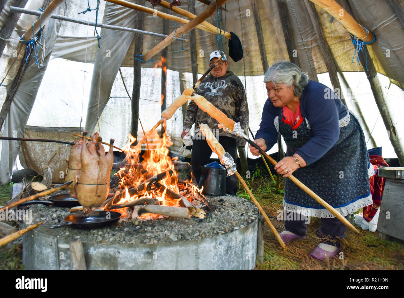 Cris sauvages de cuisson du pain bannock et oies dans un tipi dans le Nord du Québec Banque D'Images