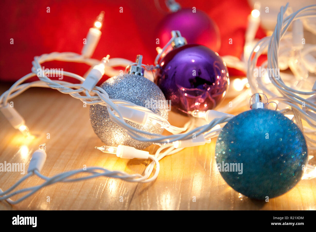 Bleu, argent et pourpre des ornements de Noël empêtré dans lumières blanches Banque D'Images