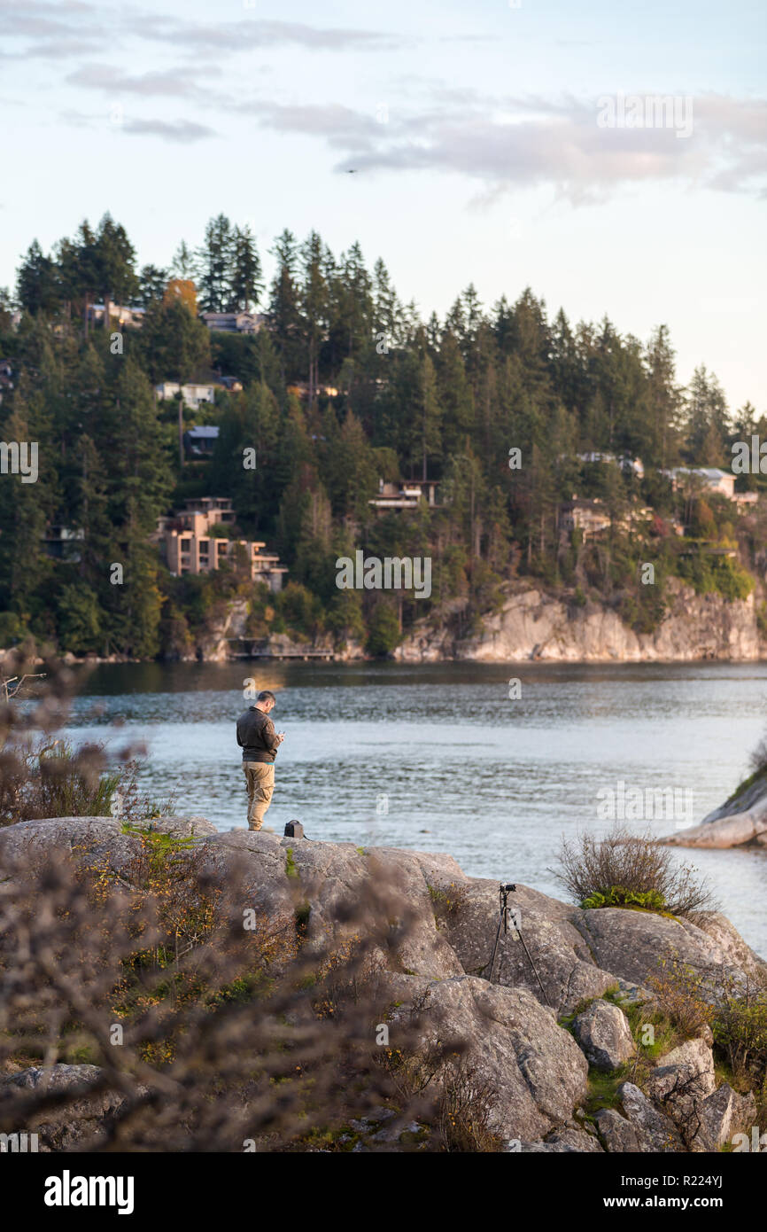 Un homme vole son drone sur l'océan au parc Whytecliff., Vancouver Ouest. Banque D'Images