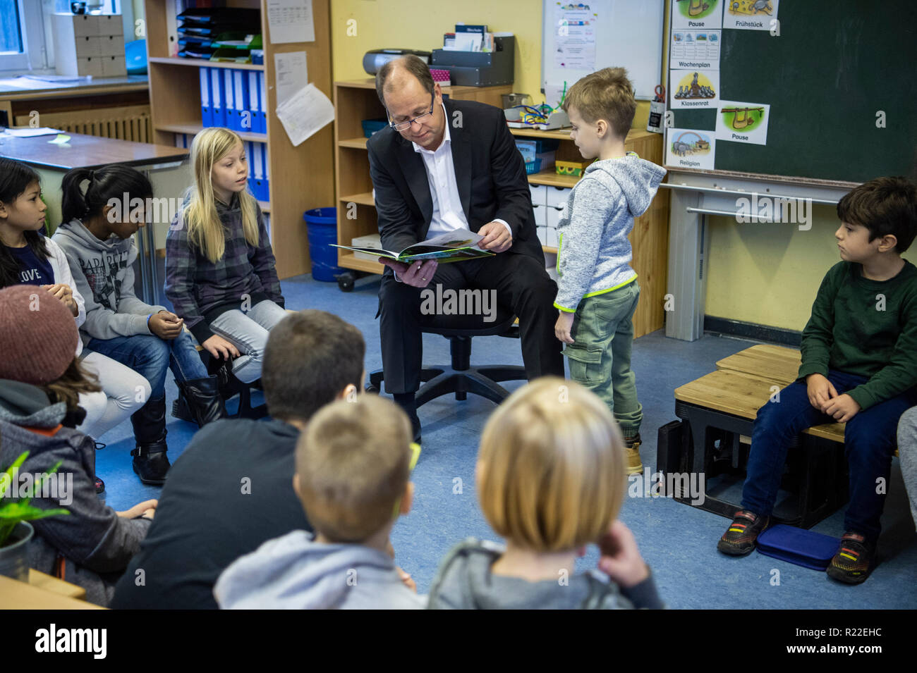 16 novembre 2018, en Rhénanie du Nord-Westphalie, Düsseldorf : Joachim Stamp (FDP, M), Ministre de l'enfance, de la famille, des réfugiés et de l'intégration en Rhénanie du Nord-Westphalie, lit le livre 'Der Grüffelo" par Julia Donaldson dans le cadre d'une journée à la lecture à l'école primaire catholique. Photo : Christophe Gateau/dpa Banque D'Images