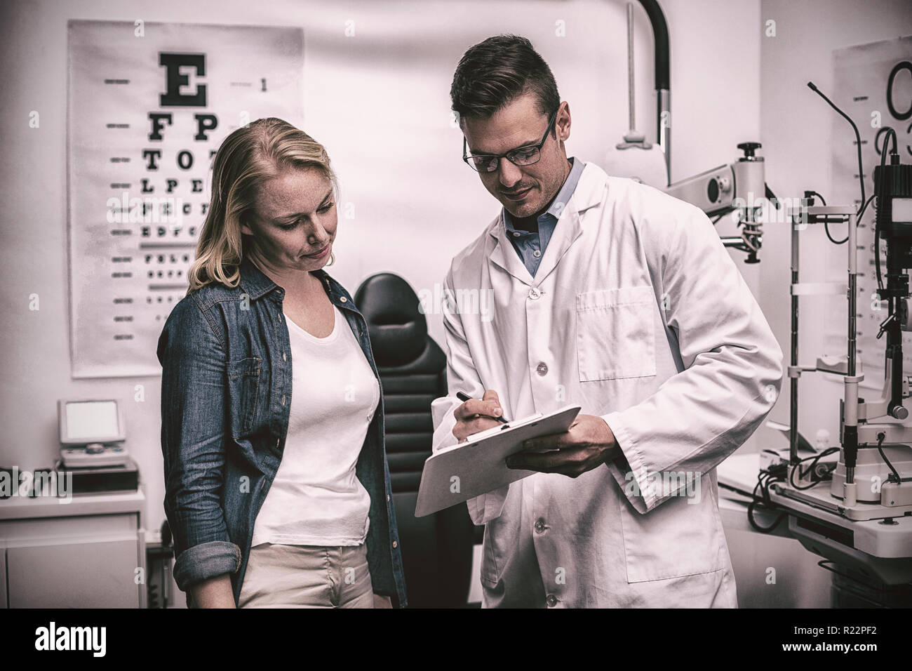 Optométriste à discuter avec l'œil du patient de sexe féminin Banque D'Images