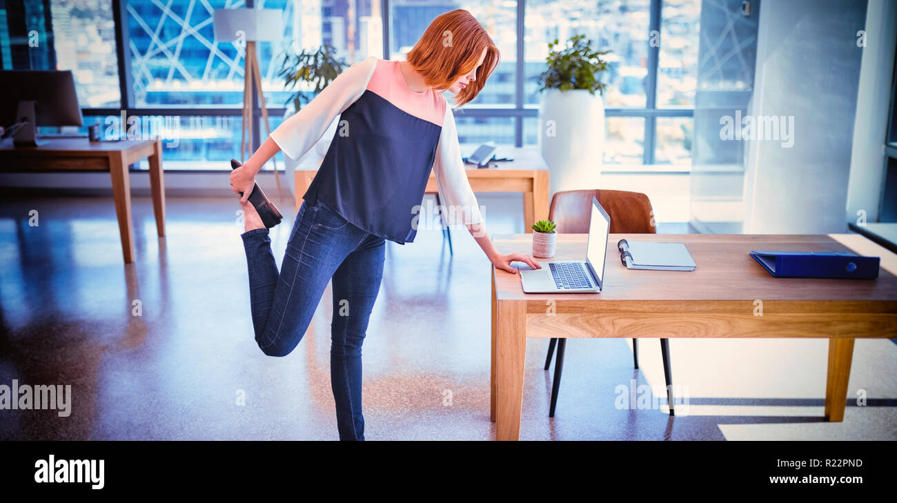 Exécutif attentif à l'aide d'ordinateur portable tout en exerçant Banque D'Images