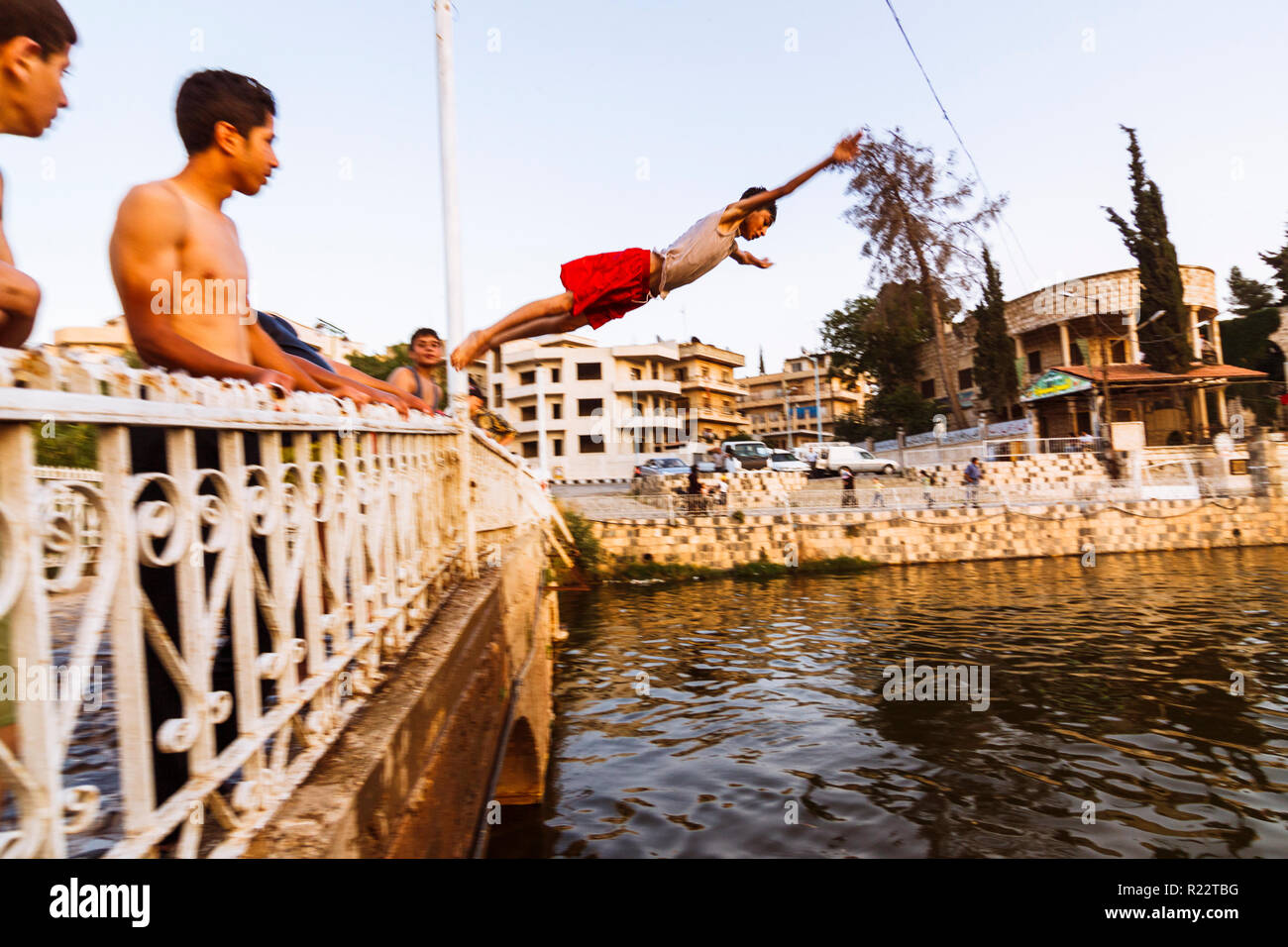 Le gouvernorat de Hama Hama, Syrie, République : adolescents jumpig dans l'eau d'une passerelle sur l'Oronte. Banque D'Images