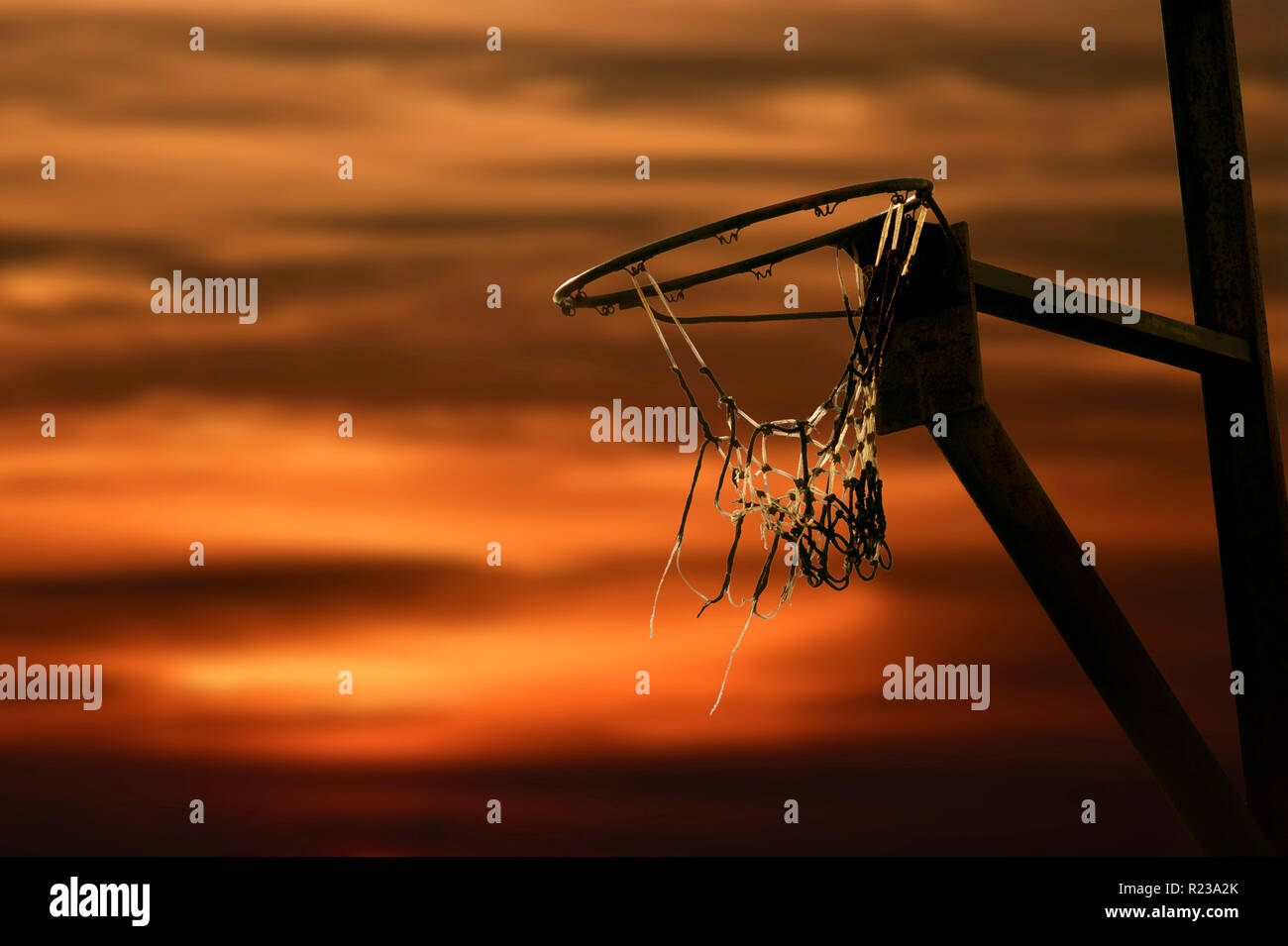 Silhouette de Rim de basket-ball au coucher du soleil Banque D'Images