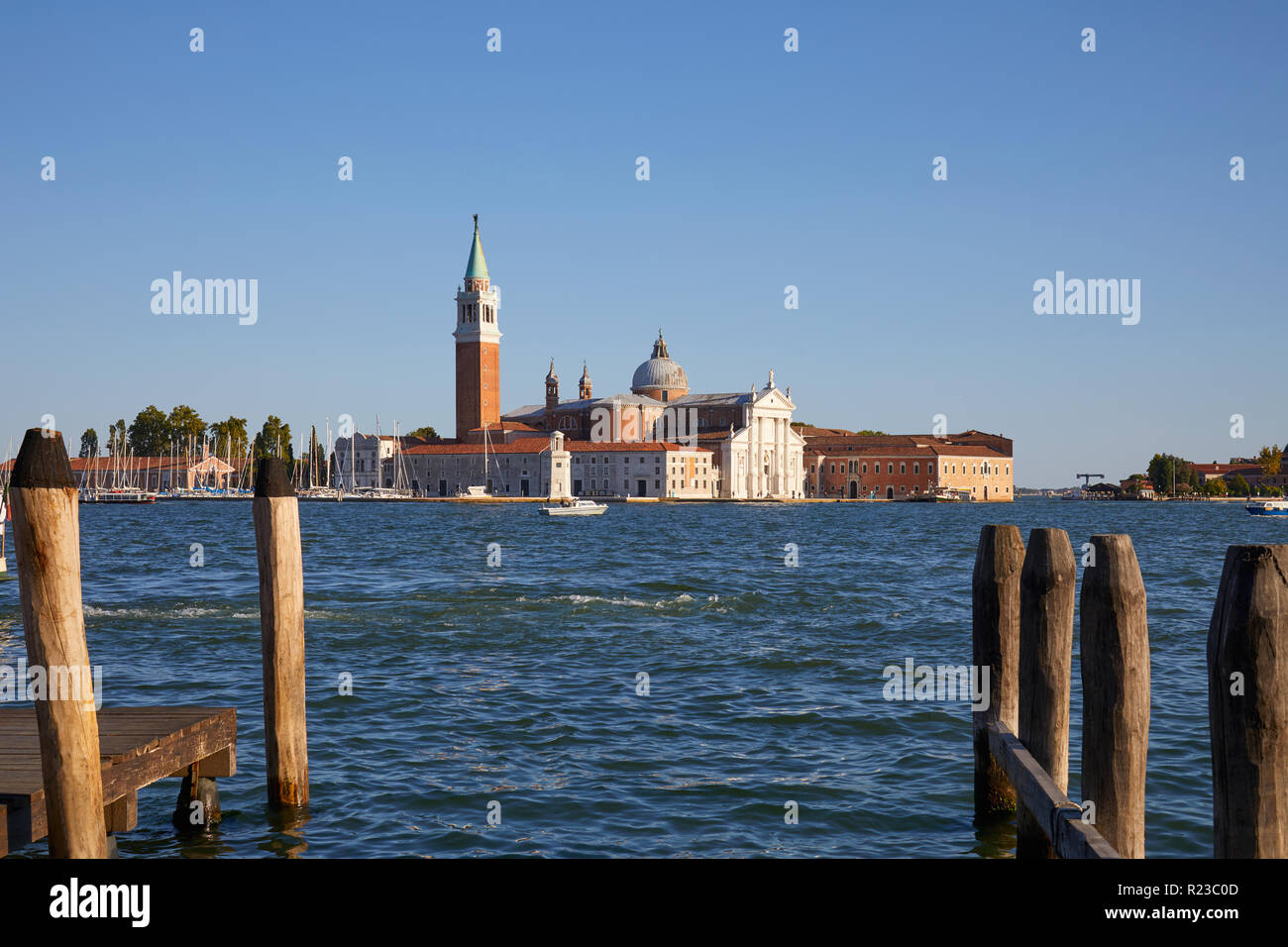 L'île de San Giorgio Maggiore et la basilique à Venise, de poteaux et de la jetée dans la lumière au coucher du soleil chaud, Italie Banque D'Images