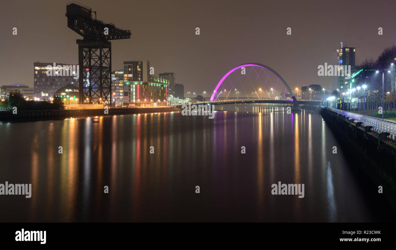 Glasgow, Scotland, UK - 5 novembre 2018 : la rivière Clyde coule sous le pont de l'Arc de Clyde et passé le monument Finnieston Crane de nuit à Glasgow. Banque D'Images