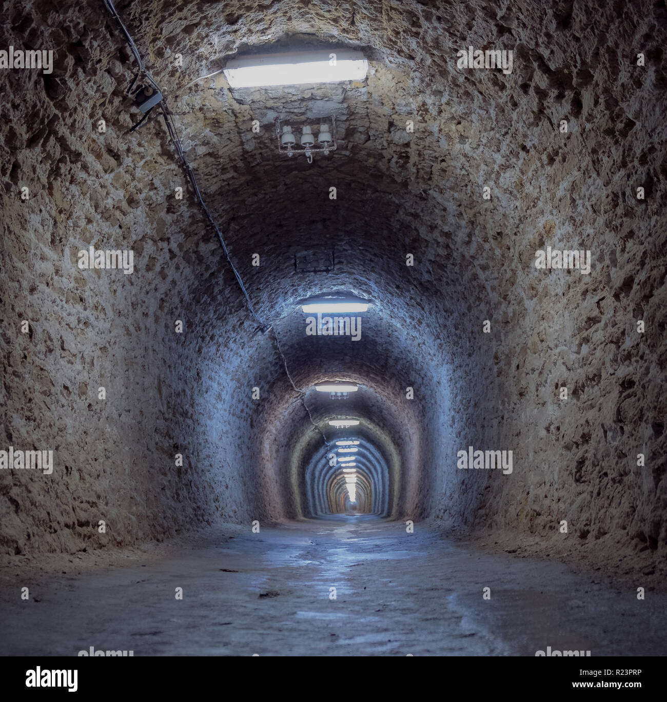 Tunnel de marche allumé créant un effet de lignes parallèles à l'infini. Tourné en tenant de la terre dans la vieille mine de sel de Turda Banque D'Images