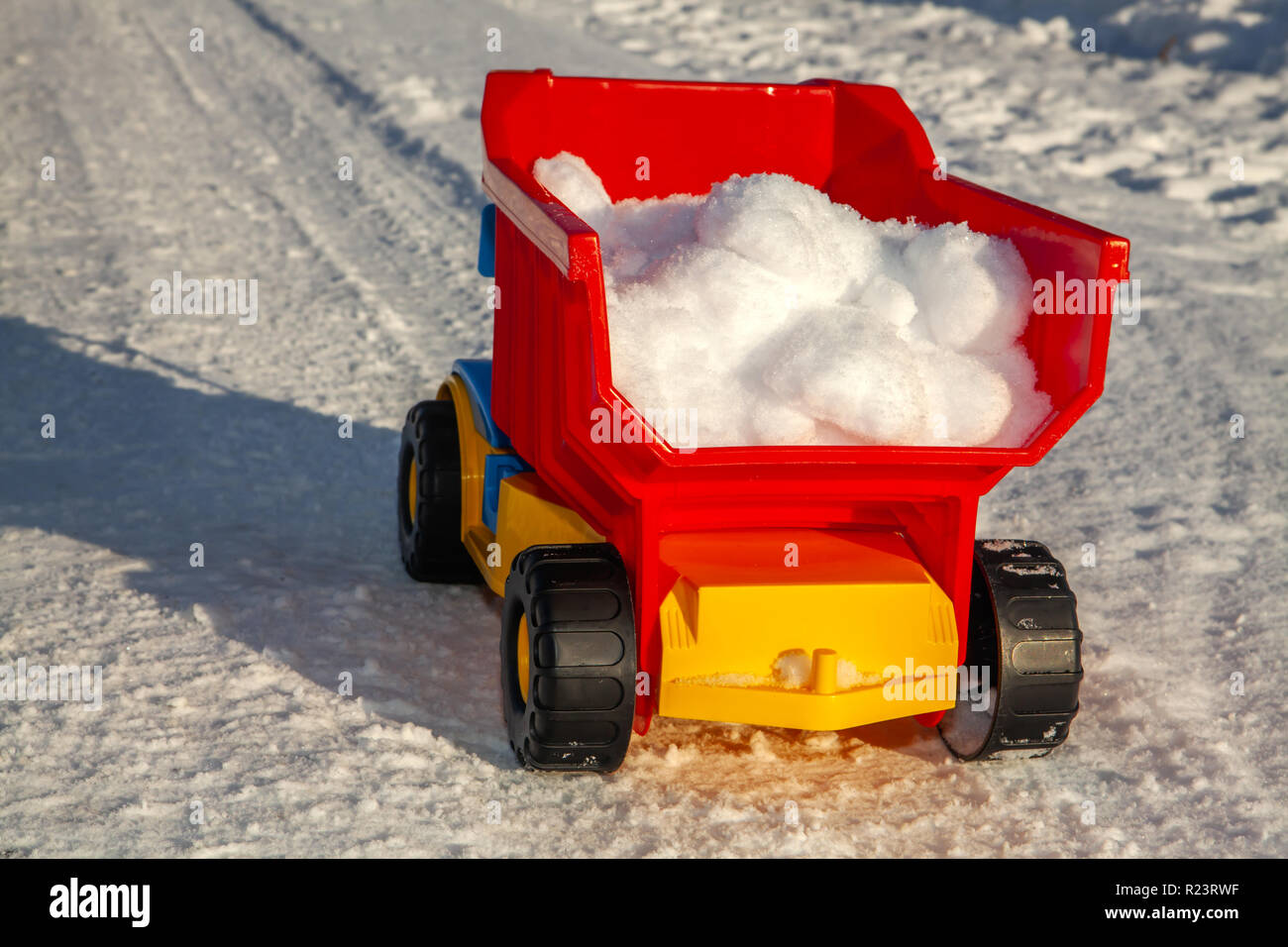 Camion jouet enlève la neige sur la route en hiver Banque D'Images