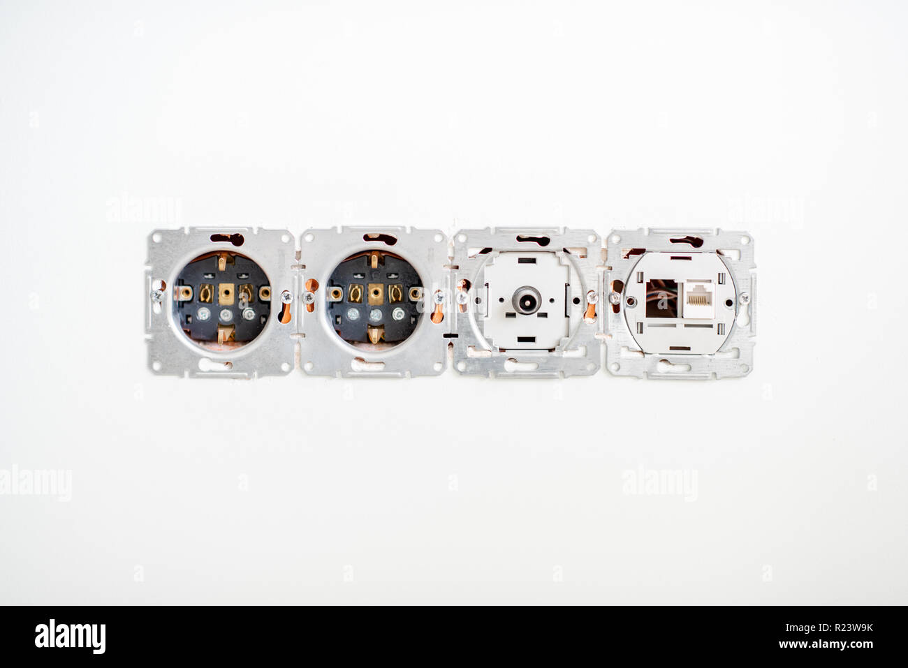 Prises électriques sans cadre sur le mur blanc à l'intérieur Banque D'Images