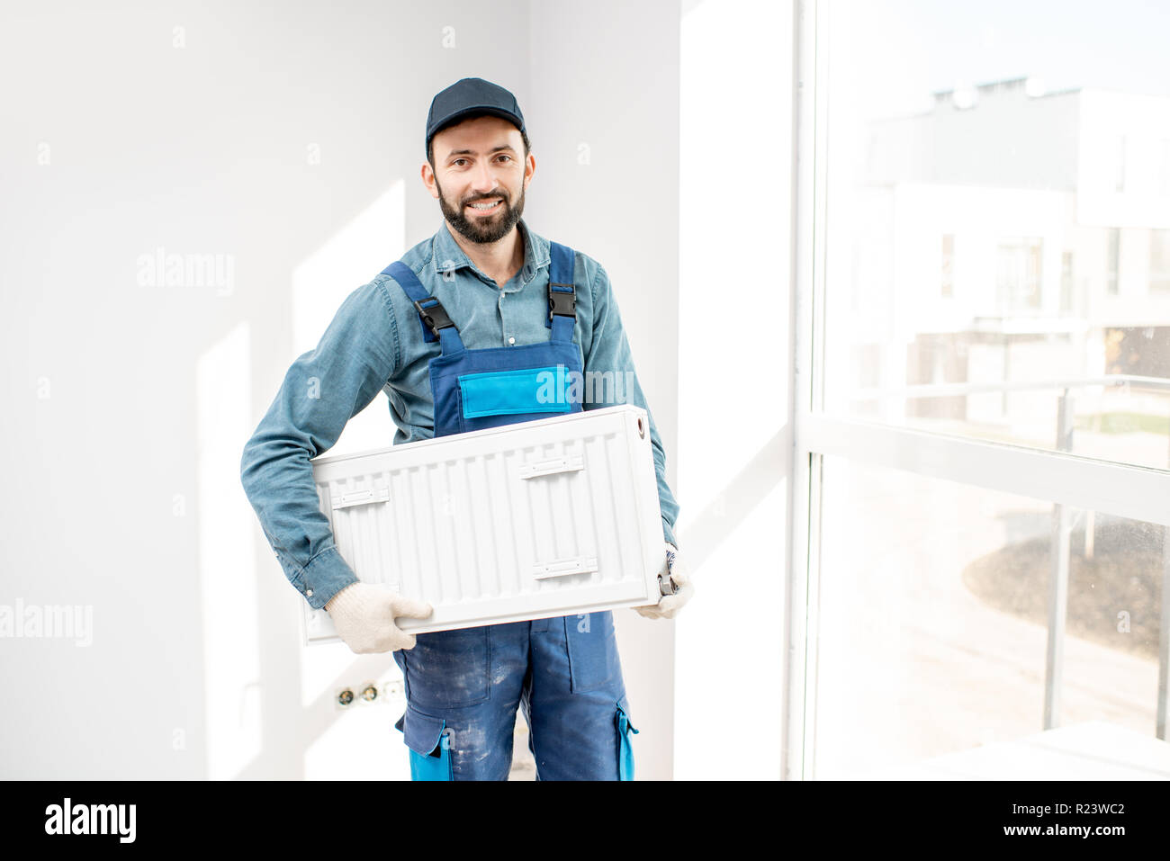 Portrait d'un ouvrier dans le radiateur de chauffage holding white room Banque D'Images