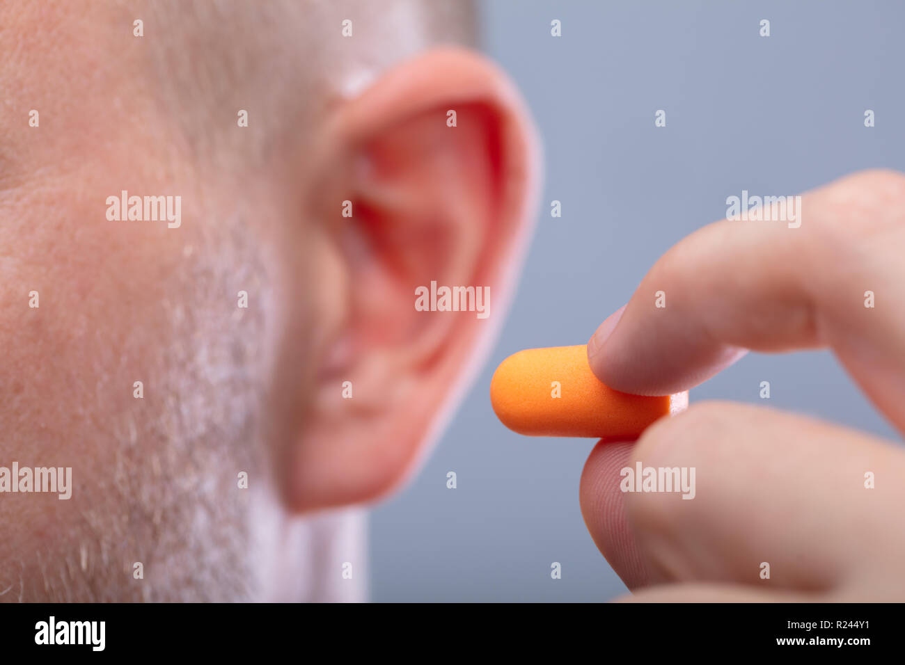 Close-up of a Man's Hand Inserting écouteur dans son oreille Banque D'Images