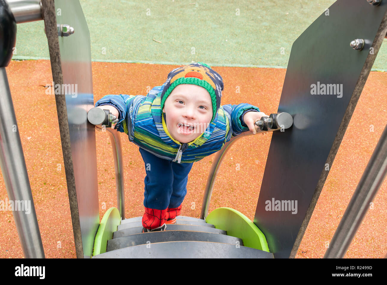 Défaut,enfants,la médecine et les gens de ce concept - jeune garçon avec un syndrome de Down qui joue dans une aire de jeux. Banque D'Images