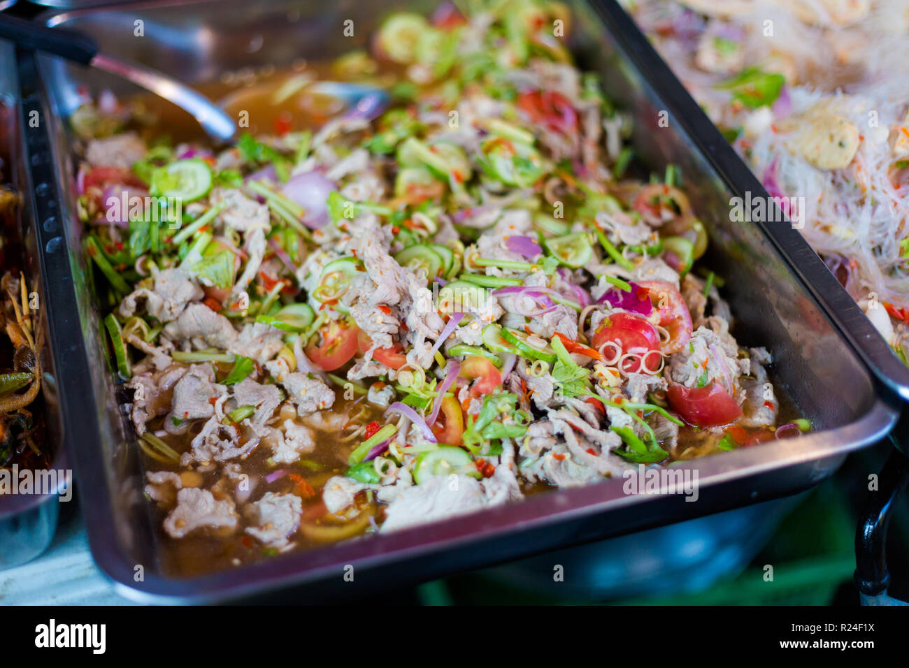 Porc épicé frais préparé salade asiatique avec légumes croquants sur le marché local à Bangkok. La cuisine thaïlandaise traditionnelle faite d'ingrédients frais. Banque D'Images