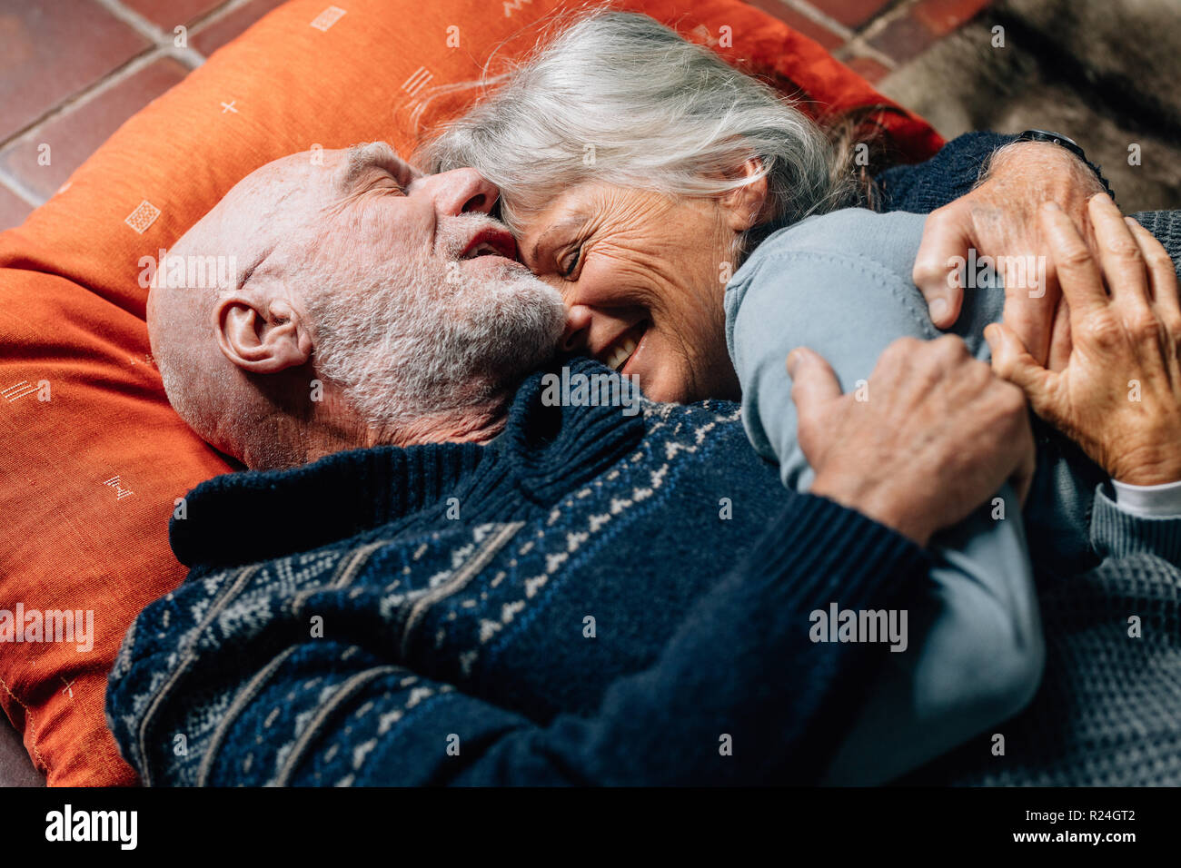 Happy senior couple hugging étage sur l'autre, par une nuit froide. Smiling senior femme dormant dans les bras de son mari heureux. Banque D'Images