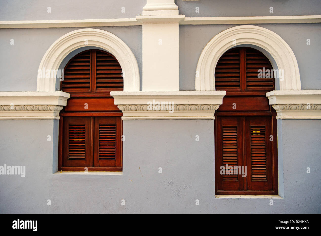 WindowBig et petites avec des volets en bois sur fond de mur gris à San Juan, Porto Rico. Maison avec façade crépi. L'asymétrie et la géométrie urbaine concept. Construction et rénovation. Banque D'Images