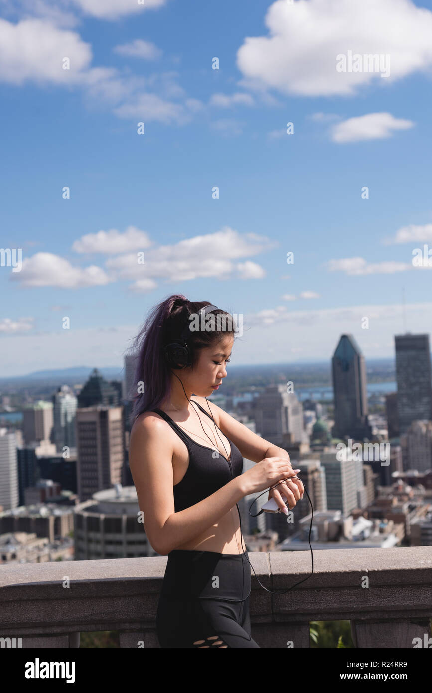 Female jogger en utilisant smartwatch Banque D'Images