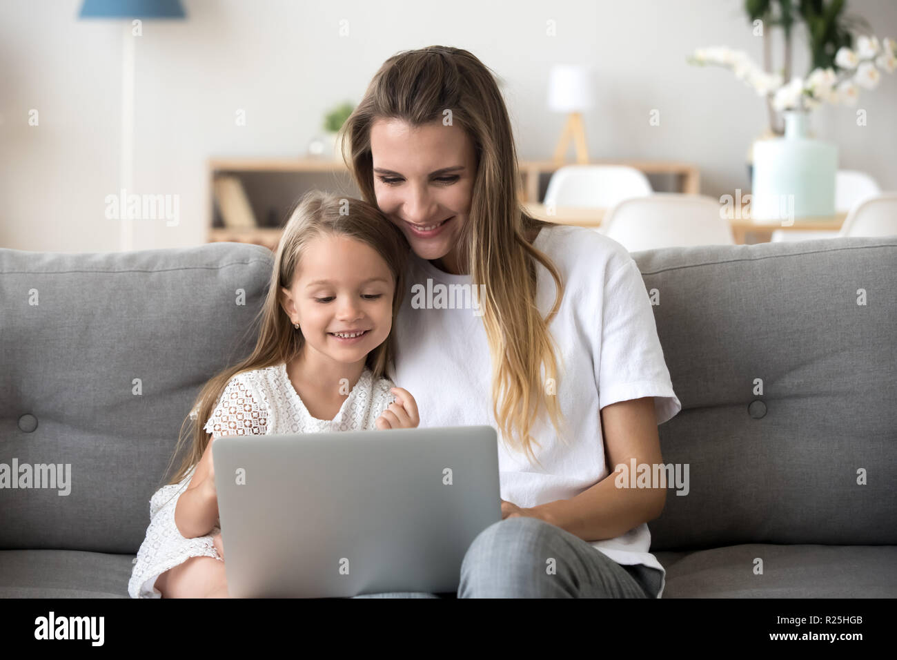 Smiling mother et kid s'amuser shopping online with laptop Banque D'Images
