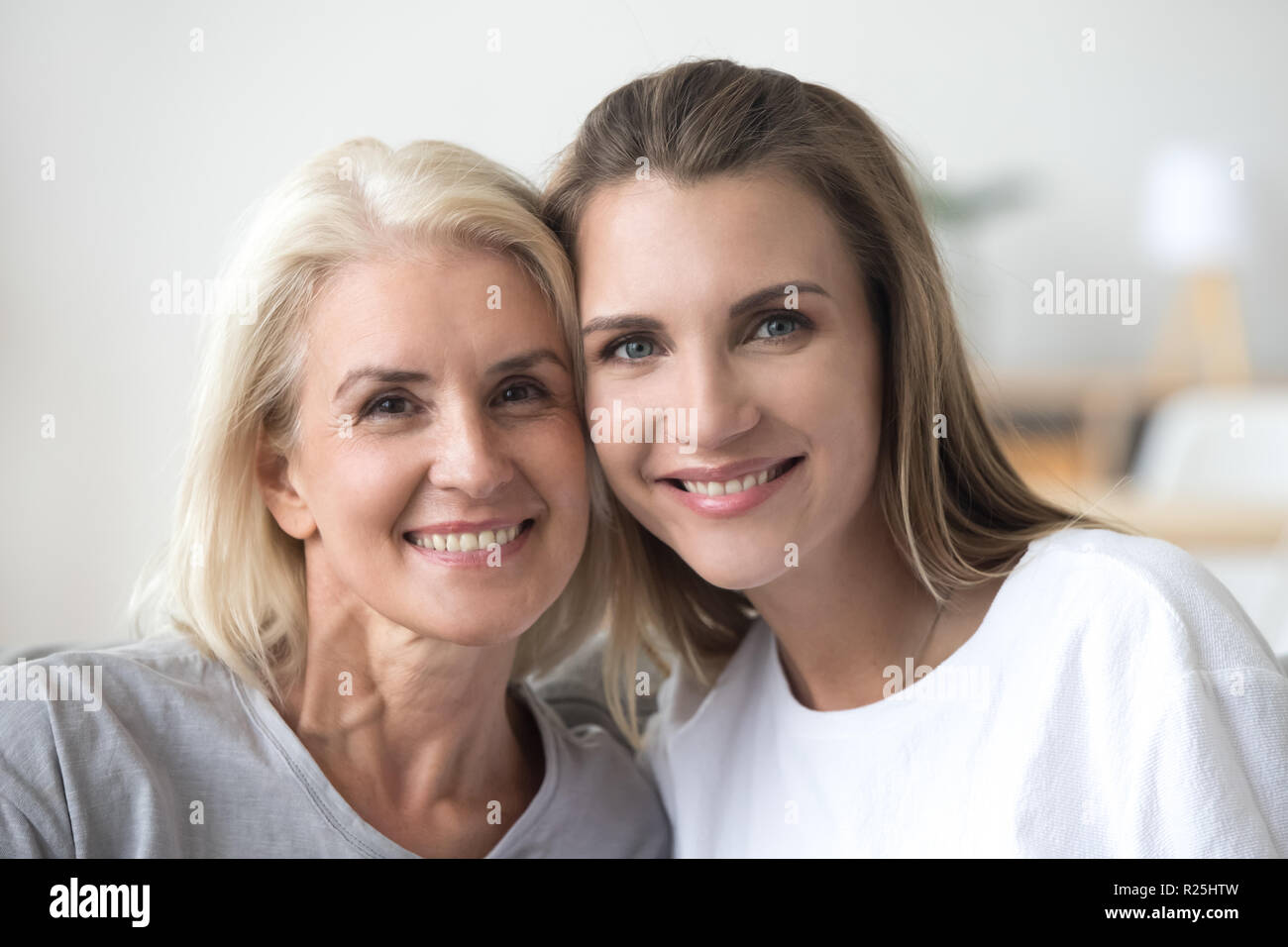 Souriante jeune femme et vieille mère looking at camera, portrait Banque D'Images