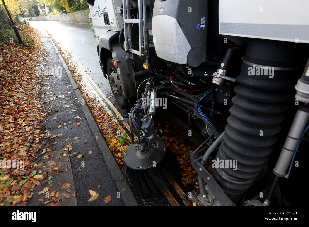 Conseil Une balayeuse nettoyage photo les feuilles le long de la route dans la région de Chichester, West Sussex, UK. Banque D'Images