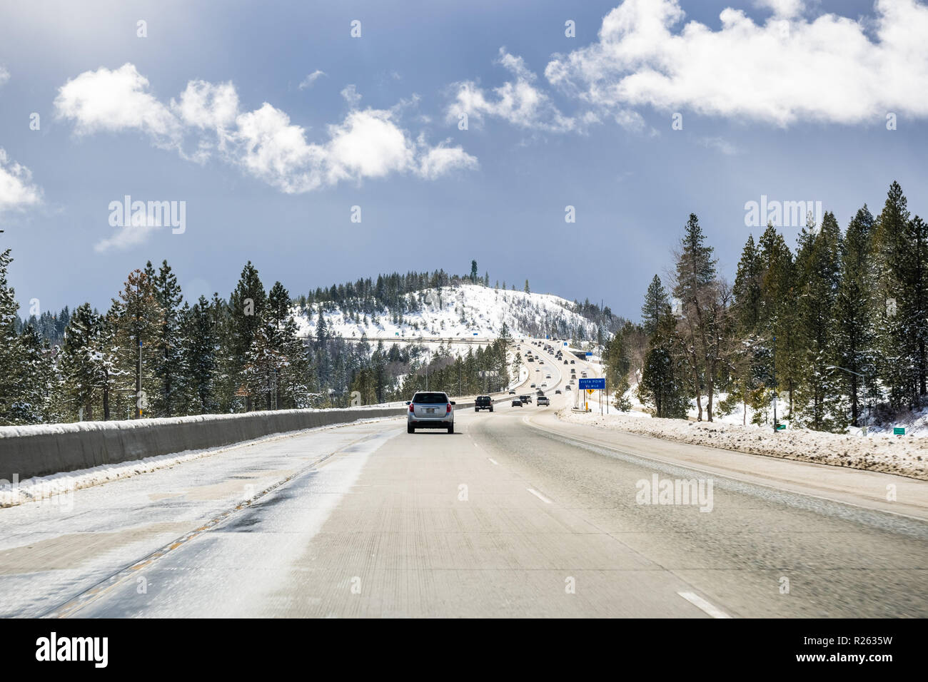 Les voitures qui circulent sur l'autoroute I80 à travers la Sierra montagnes à proximité du lac Tahoe sur une journée d'hiver ensoleillée ; la route a été effacé sur la neige, en Californie Banque D'Images