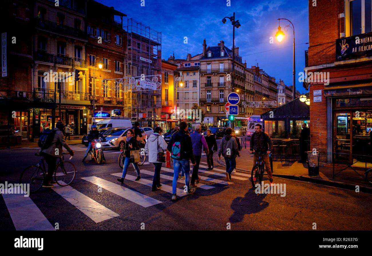 Les personnes qui traversent la route de nuit - Scène de rue à Toulouse, France Banque D'Images