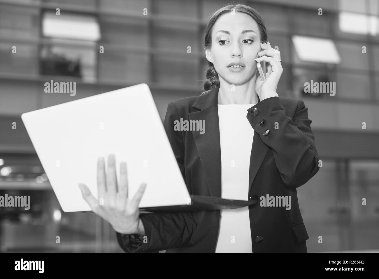 Femme chef de bureau est en train de discuter au téléphone un contrat à l'extérieur près de l'office. Banque D'Images
