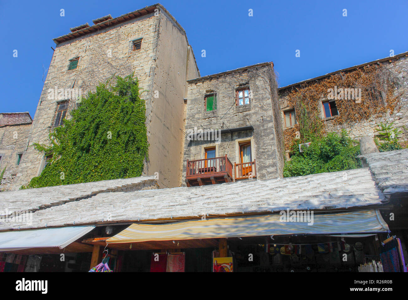 Août 2013, Mostar. Les bâtiments en pierre traditionnel avec balcon terrasse dans la vieille ville. Trous de balle de la guerre sont visibles sur le mur de côté de Banque D'Images