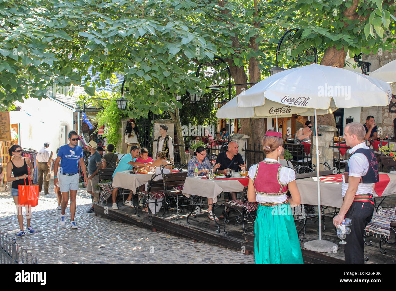 Août 2013, Mostar. Restaurant en plein air avec des invités coin extérieur. Les serveurs sont habillés en costumes traditionnels dans le vieux Towm. Banque D'Images