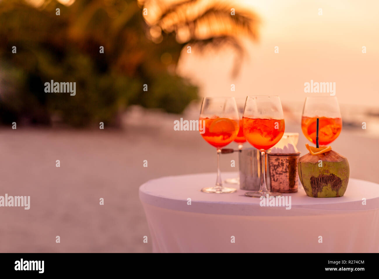 Les personnes ayant des trouble-fête de plage au coucher du soleil en été locations - image flou artistique - Notion d'Aperol vie nocturne avec des cocktails et musique, spectacles Banque D'Images