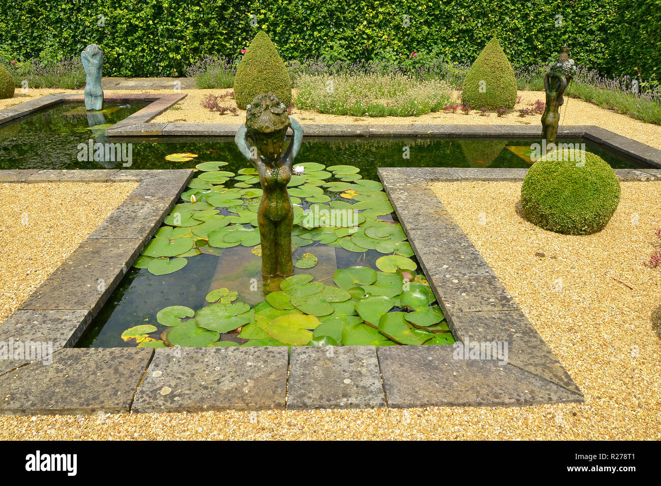 Dispositif de L'EAU DANS UNE MAISON DE JARDIN. Août 2018. OAKHAM, Rutland, Angleterre. Un jardin d'eau avec formelle decortive et statues topiaires Banque D'Images